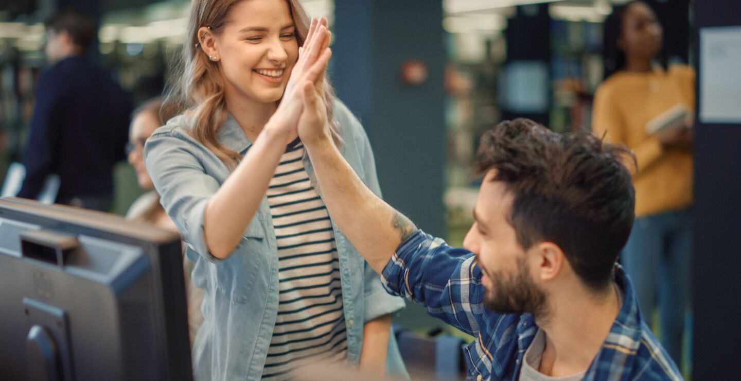 A woman and a man giving a high five too each other